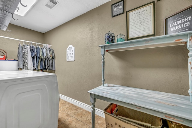 laundry room with light tile patterned floors and washer / dryer