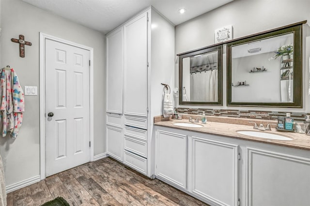 bathroom with backsplash, vanity, and wood-type flooring