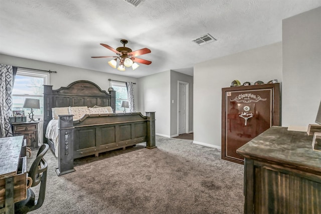 bedroom featuring dark colored carpet, ceiling fan, and a textured ceiling