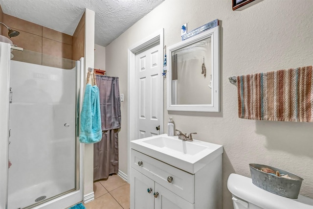 bathroom featuring vanity, tile patterned flooring, toilet, a textured ceiling, and a shower with shower door