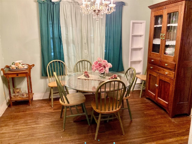 dining space with built in shelves, dark hardwood / wood-style floors, and a notable chandelier