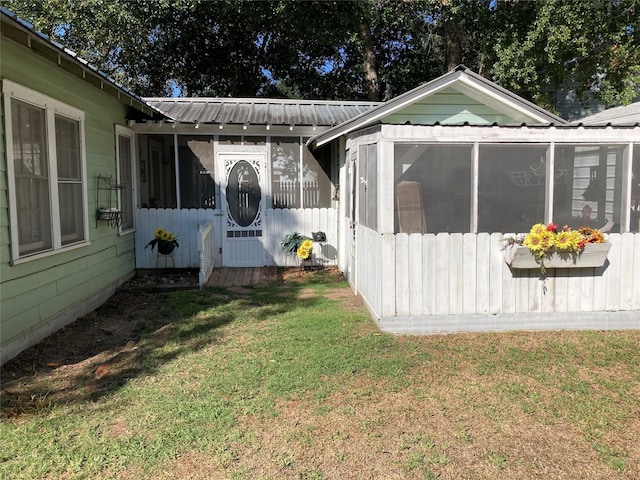 exterior space with a sunroom and a yard