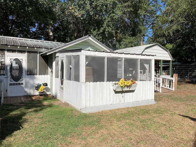 back of property featuring a sunroom and a yard