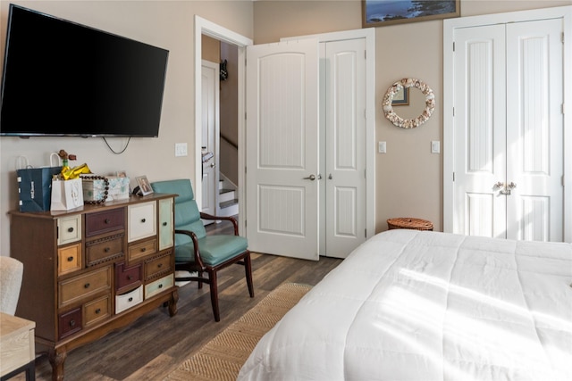 bedroom with dark hardwood / wood-style flooring and multiple closets