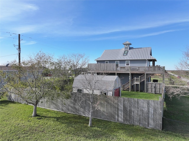 rear view of house featuring a lawn and a wooden deck