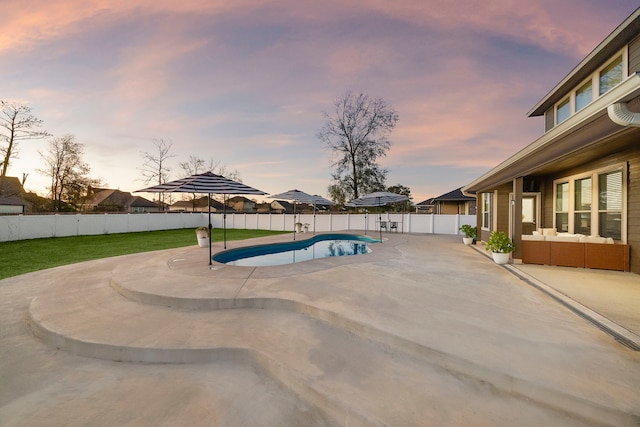 pool at dusk with a patio area