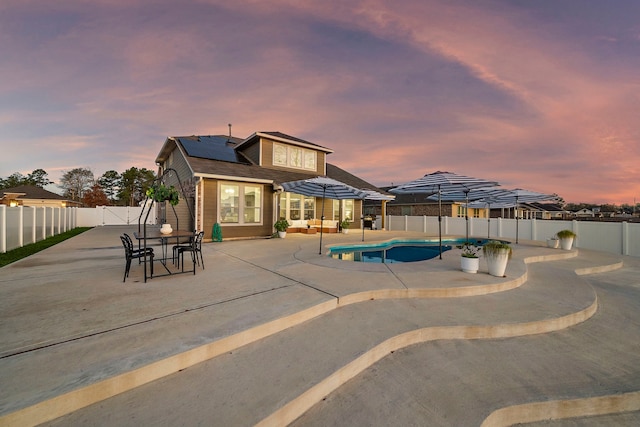 pool at dusk featuring outdoor lounge area and a patio area