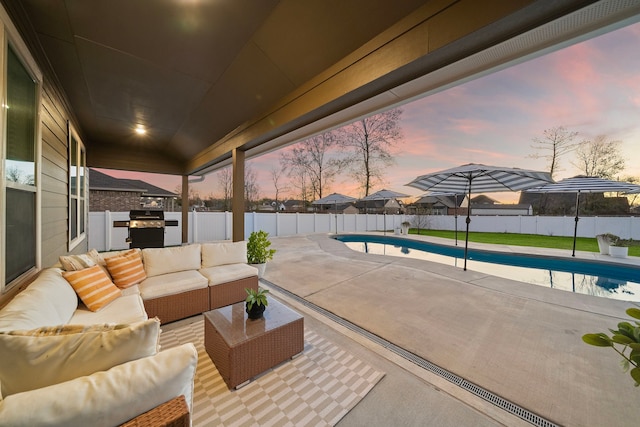 patio terrace at dusk with outdoor lounge area, a fenced in pool, and area for grilling