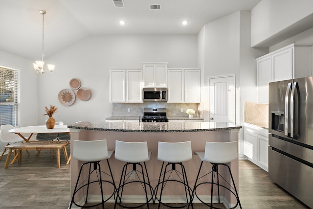 kitchen with appliances with stainless steel finishes, a kitchen island with sink, and white cabinets