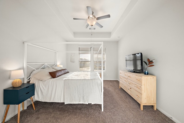 carpeted bedroom featuring ceiling fan and a tray ceiling