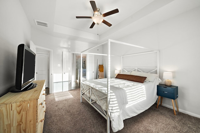 bedroom featuring ceiling fan, a tray ceiling, and carpet flooring