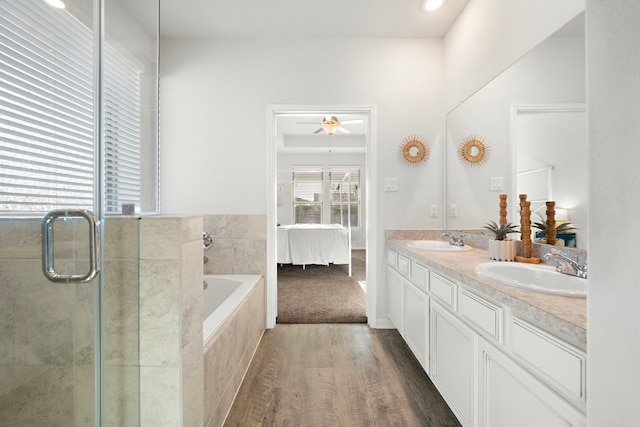 bathroom with ceiling fan, wood-type flooring, plus walk in shower, and vanity