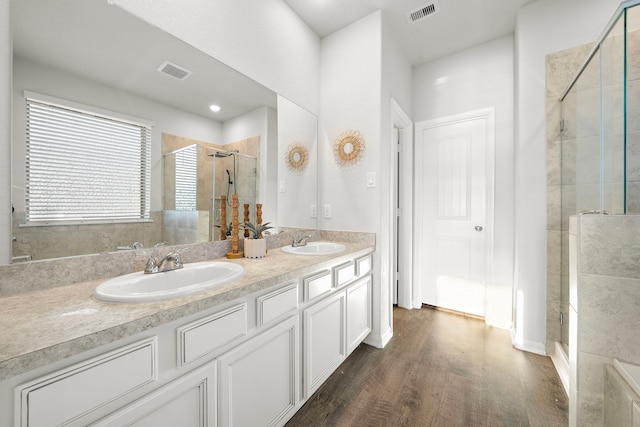 bathroom featuring vanity, a shower with shower door, and wood-type flooring