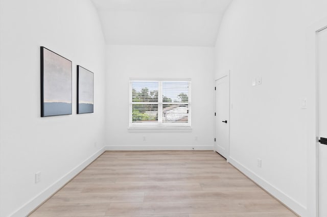 spare room with lofted ceiling and light hardwood / wood-style flooring