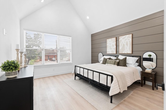 bedroom with high vaulted ceiling and light hardwood / wood-style floors