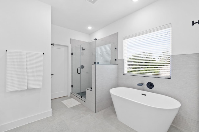 bathroom with tile patterned flooring and independent shower and bath