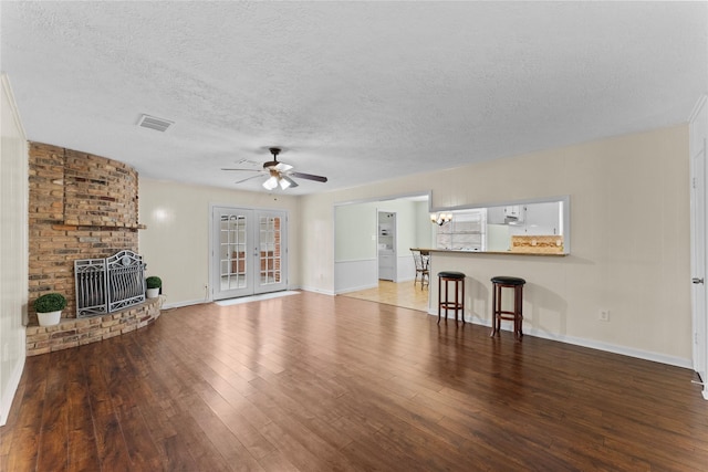 unfurnished living room featuring hardwood / wood-style flooring, ceiling fan, a healthy amount of sunlight, and a textured ceiling