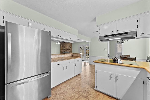 kitchen featuring backsplash, stainless steel refrigerator, ceiling fan, and white cabinets