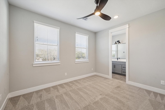 unfurnished bedroom with connected bathroom, ceiling fan, and light colored carpet