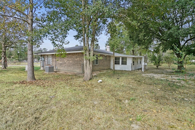 back of house with a lawn and central AC