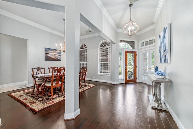 entryway with french doors, dark hardwood / wood-style flooring, crown molding, and a notable chandelier