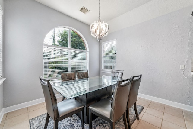 dining space featuring a chandelier, light tile patterned floors, and vaulted ceiling