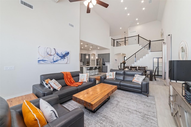 living room featuring ceiling fan and a towering ceiling