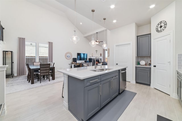 kitchen with pendant lighting, a center island with sink, gray cabinetry, and sink