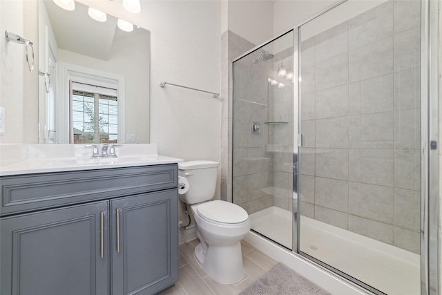 bathroom with vanity, toilet, and a shower with door