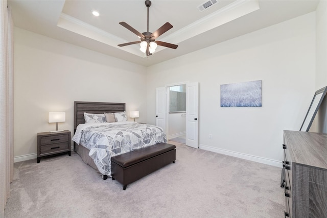 carpeted bedroom with ceiling fan, ornamental molding, and a tray ceiling