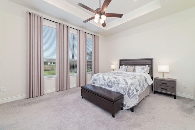 bedroom with ceiling fan, a raised ceiling, and light colored carpet