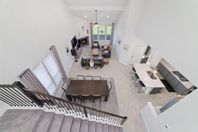 interior space featuring a towering ceiling, light hardwood / wood-style flooring, ceiling fan, and sink