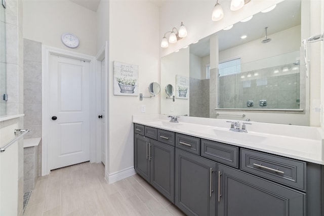 bathroom with a tile shower and vanity