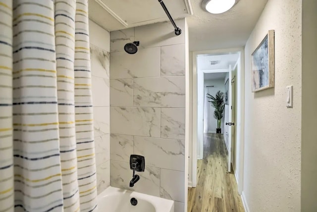 bathroom with hardwood / wood-style floors and shower / tub combo with curtain