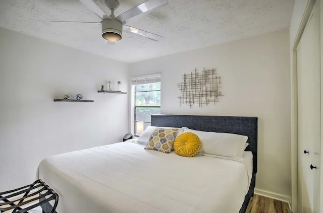 bedroom with wood-type flooring, a textured ceiling, a closet, and ceiling fan