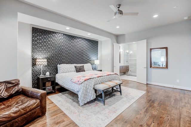 bedroom featuring light wood-type flooring, ensuite bathroom, and ceiling fan