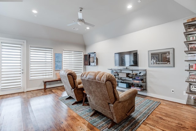 living room featuring ceiling fan, light hardwood / wood-style floors, and lofted ceiling