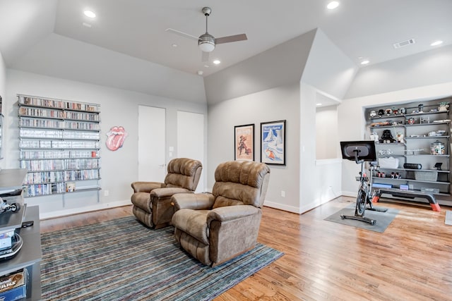 sitting room with ceiling fan, built in features, wood-type flooring, and lofted ceiling