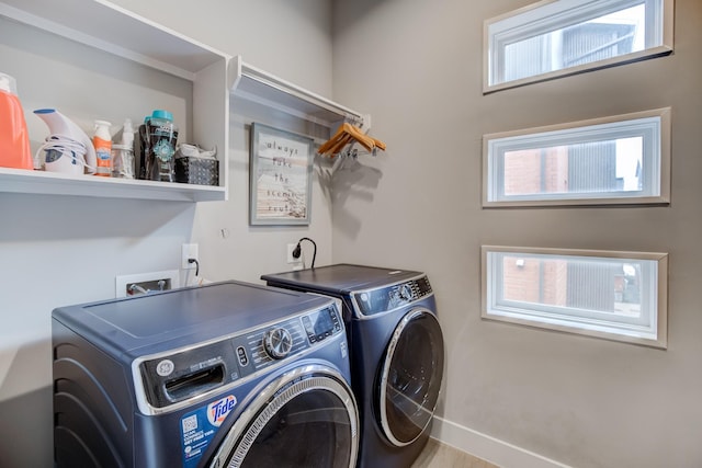 clothes washing area featuring washer and clothes dryer and a healthy amount of sunlight