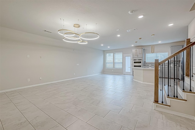 unfurnished living room with light tile patterned floors and a notable chandelier