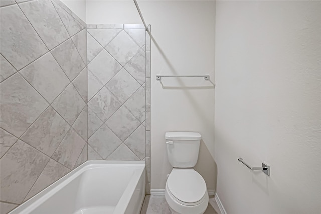 bathroom featuring tiled shower / bath combo and toilet