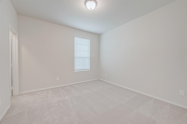 spare room with light carpet and a textured ceiling