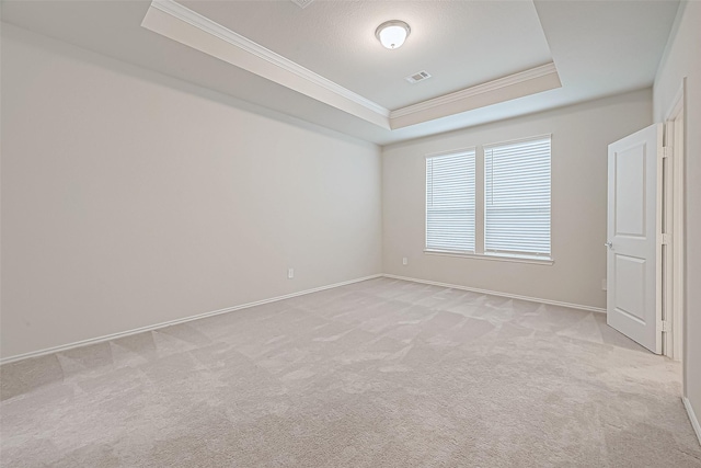 carpeted empty room with a tray ceiling, a textured ceiling, and ornamental molding