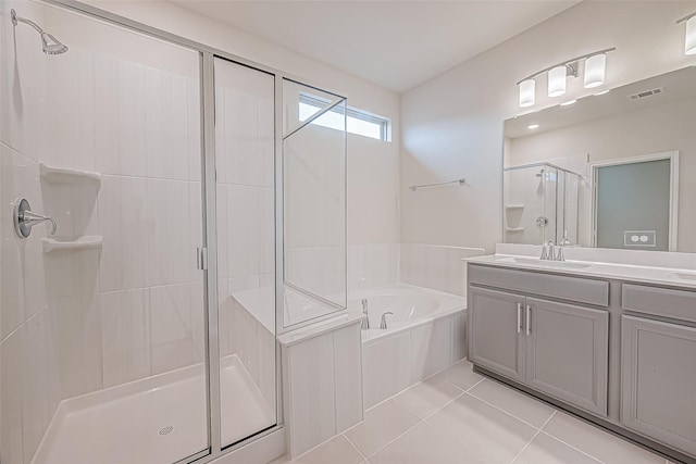 bathroom with tile patterned flooring, vanity, and separate shower and tub