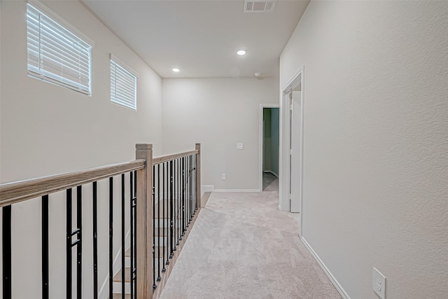 hall with light colored carpet