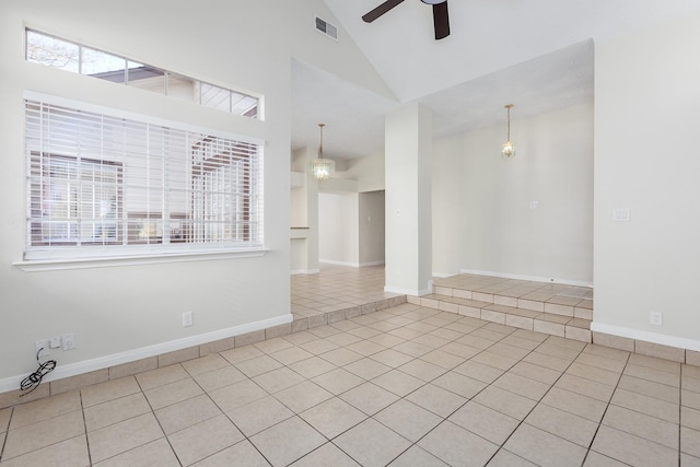 tiled empty room with high vaulted ceiling and ceiling fan