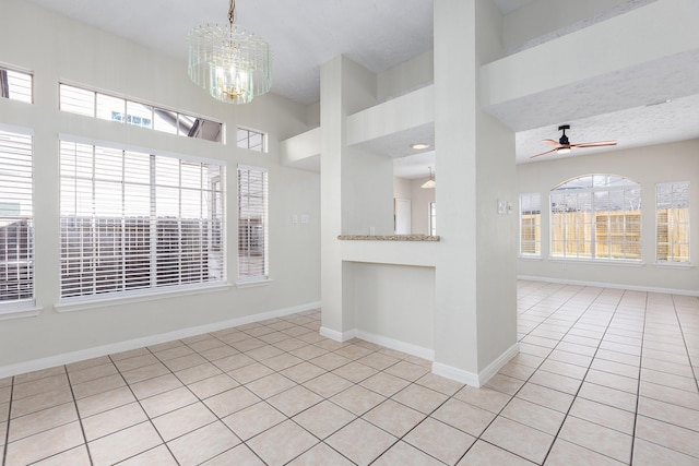 kitchen featuring light tile patterned floors, pendant lighting, and ceiling fan with notable chandelier