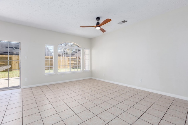 tiled empty room featuring ceiling fan and a textured ceiling