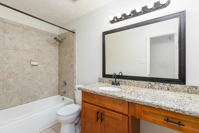 full bathroom with vanity, tile patterned flooring, tiled shower / bath combo, toilet, and a textured ceiling