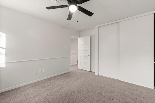 unfurnished bedroom with carpet, ceiling fan, and a closet